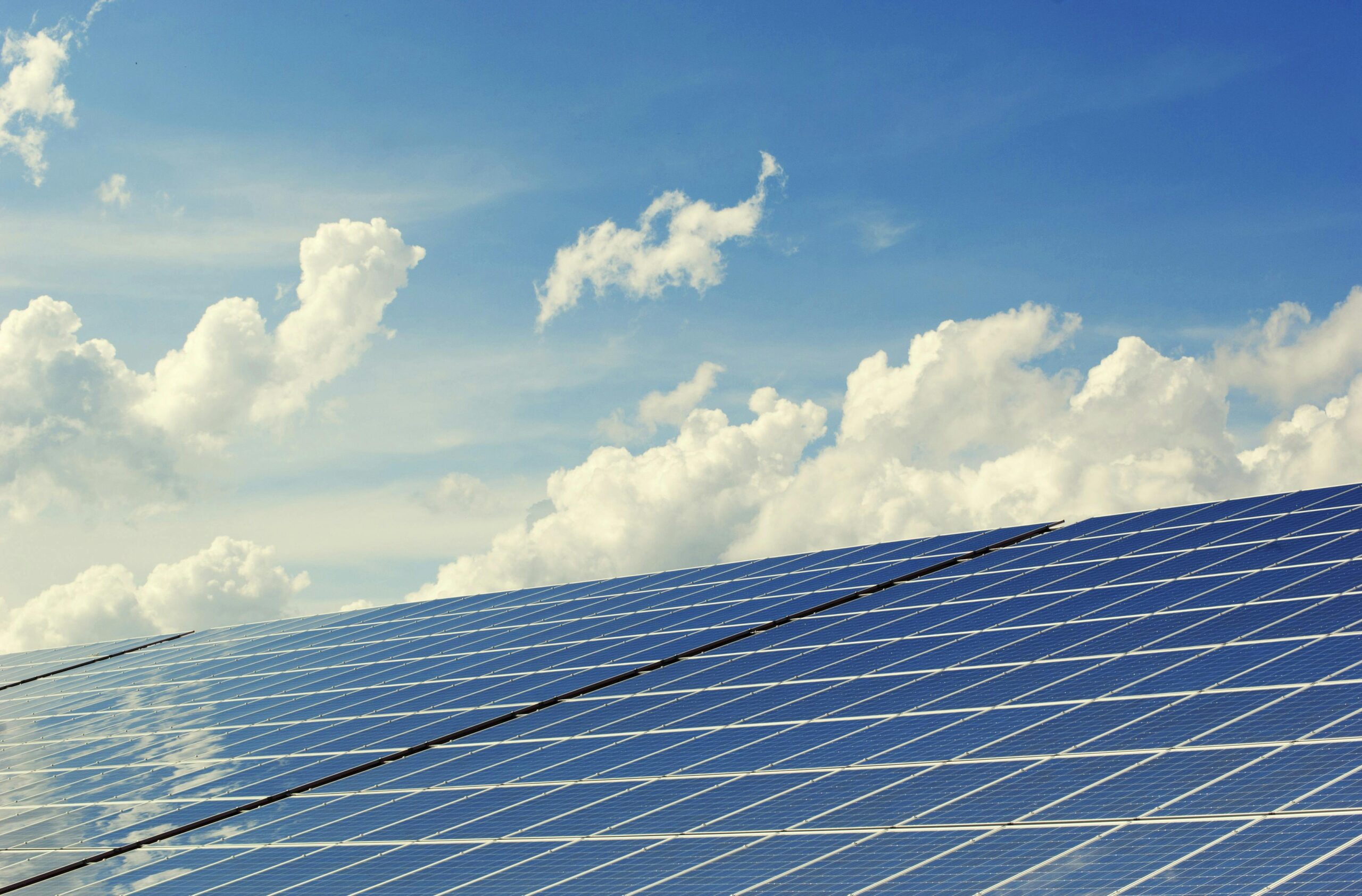 pexels photo 356036 356036 Sleek modern solar panels under a vibrant blue sky with clouds, symbolizing clean energy.
